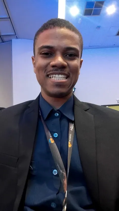 Contador sorrindo em um evento, de crachá