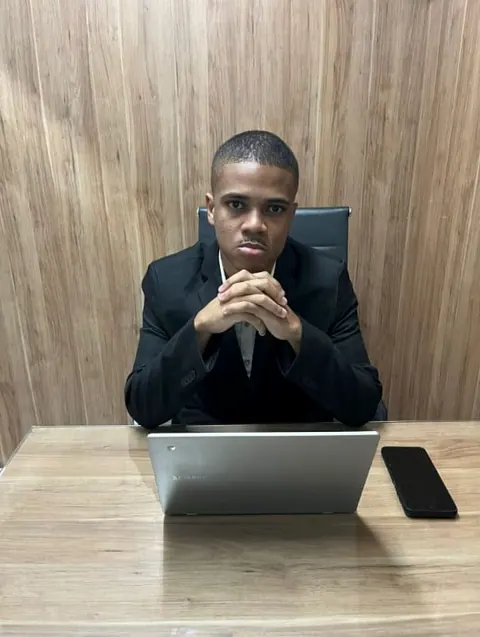 Contador sentado à mesa de trabalho com o notebook, de mãos juntas
